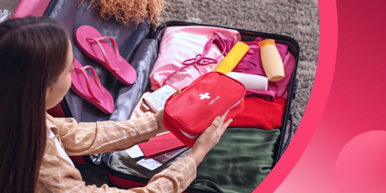 An international student adds a first aid kit to their suitcase.