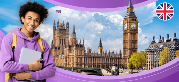 An international student stands in front of part of the London, UK skyline.